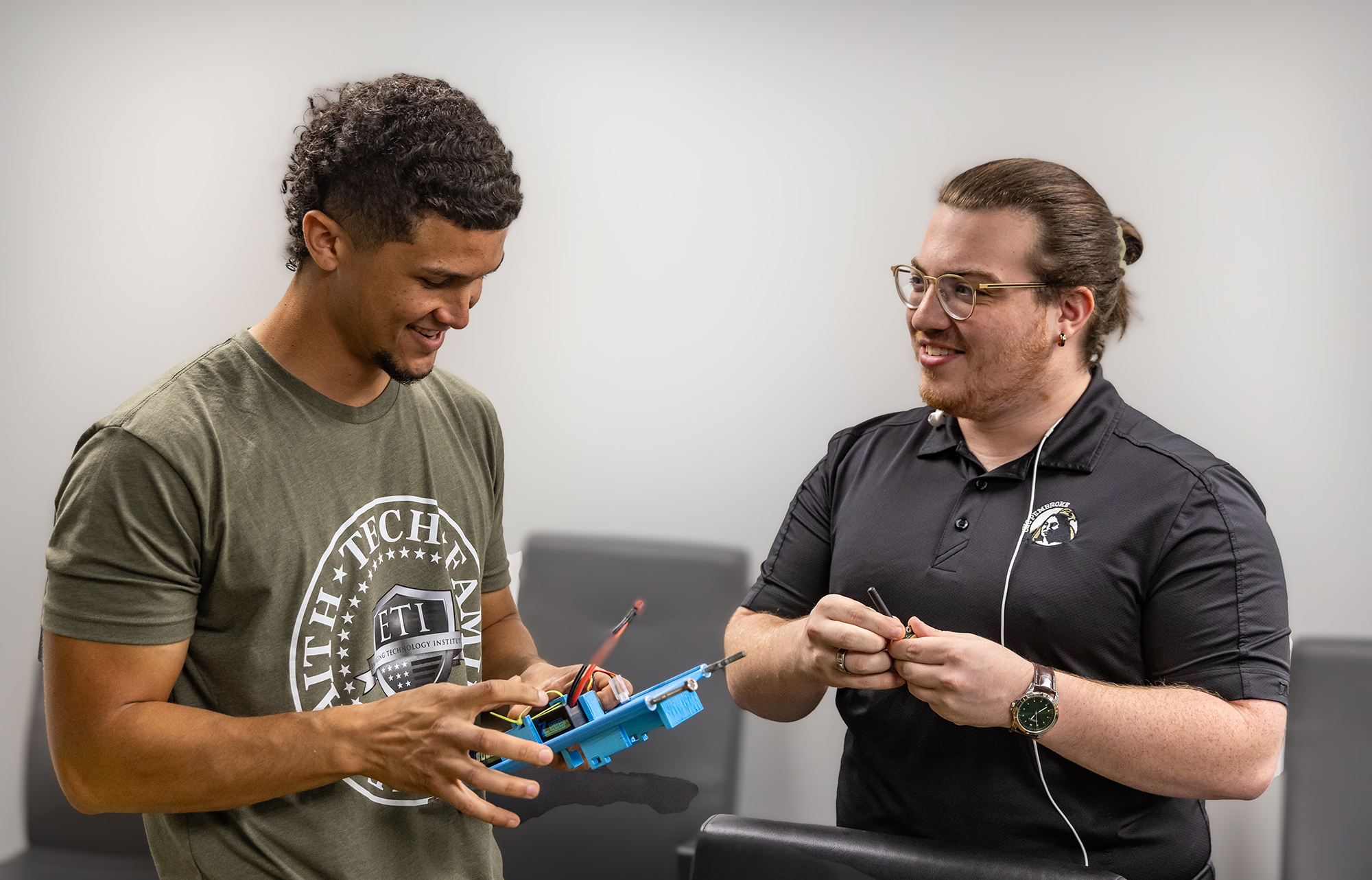 UNCP IT staff assist a community member at a help desk, representing the Division of Information Technology.