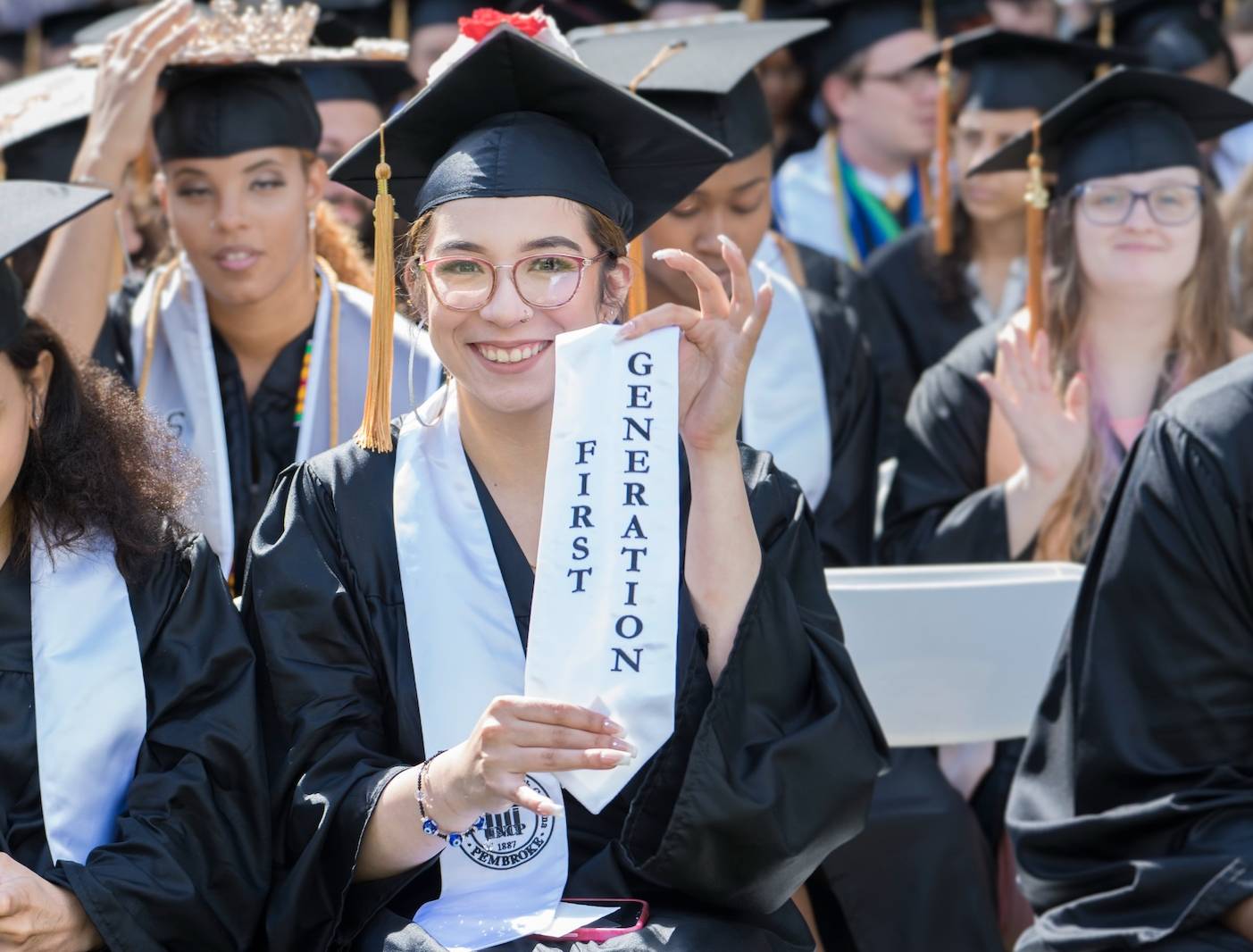 A UNCP graduate holds a first-generation student stole at the undergraduate commencement ceremony.