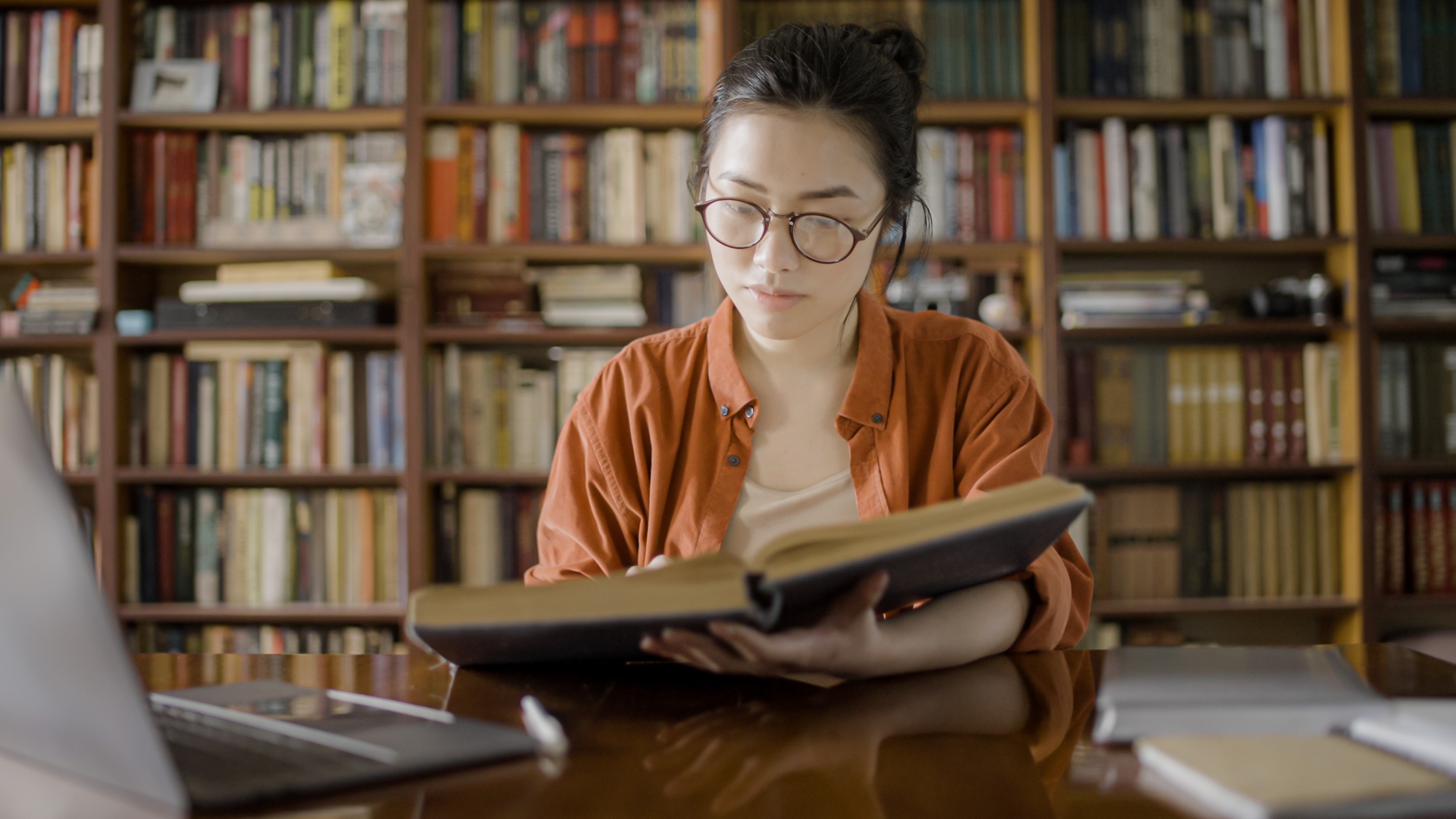 student in older library reading book