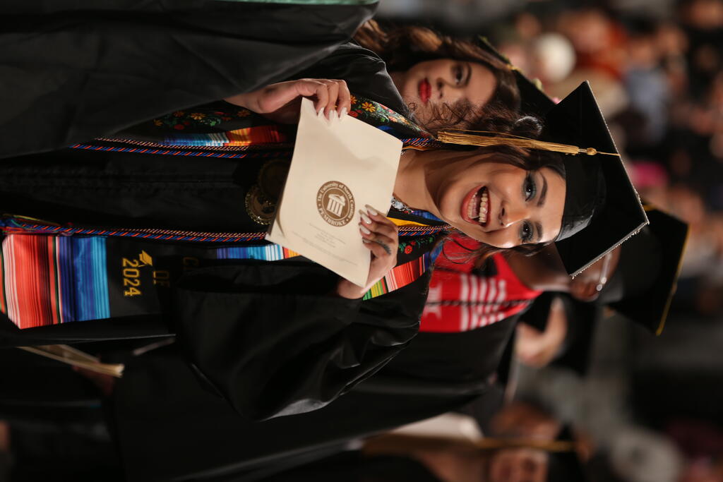 Jimena Becerril proudly shows off her diploma at Winter Commencement