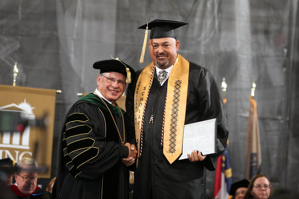 Shawn Clark accepts his diploma from Chancellor Robin Gary Cummings on Saturday, December 14, 2024