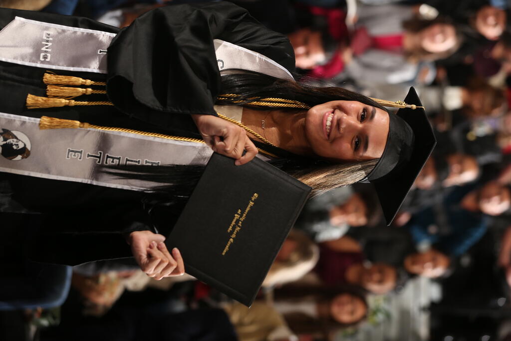 Precious Daley, a standout volleyball player, shows off her diploma at UNC Pembroke's Winter Commencement