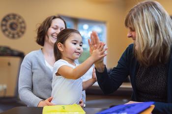 Young girl proud of physical therapy giving a high five.